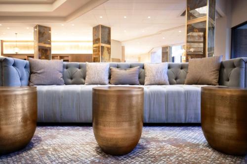 a living room with a couch and some pillows at Hilton Richardson Dallas, TX in Richardson