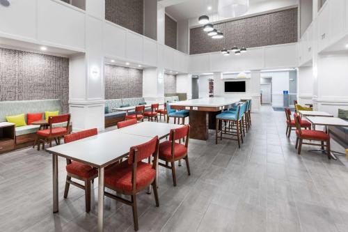 a dining room with tables and chairs and a tv at Hampton Inn & Suites Dallas I-30 Cockrell Hill, Tx in Dallas