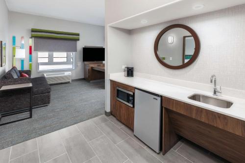 a kitchen and living room with a sink and a mirror at Hampton Inn & Suites Dallas I-30 Cockrell Hill, Tx in Dallas