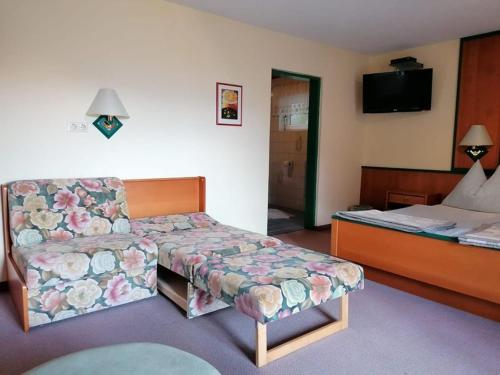 una camera con divano, letto e sedia di Apartments Rauter ad Annenheim