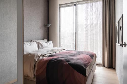 a bedroom with a bed and a large window at 348 Suites Short Stay in The Hague