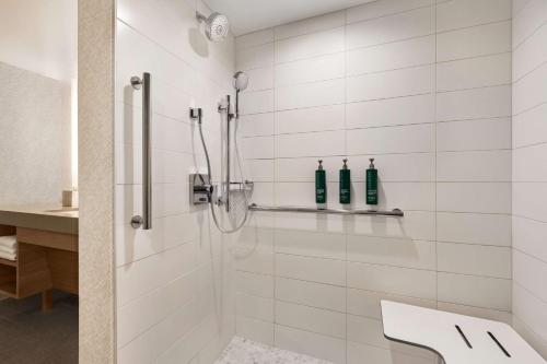 a white bathroom with a shower with two bottles at Doubletree By Hilton Columbus Dublin in Dublin