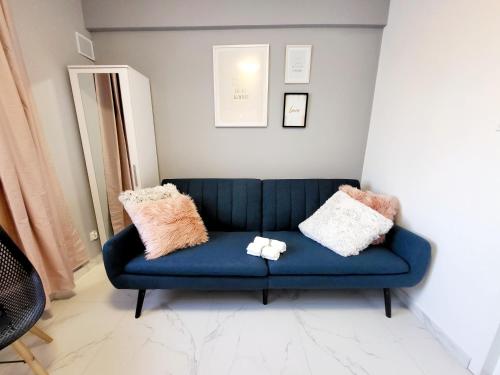 a blue couch in a living room with pillows on it at Mini Apartamenty Poznań in Poznań