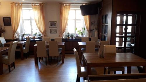 a dining room with tables and chairs and windows at Hotel Krone Lindow in Lindow