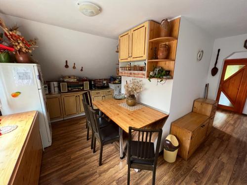 een keuken met een houten tafel en stoelen en een koelkast bij HuniHáz Apartman in Sovata
