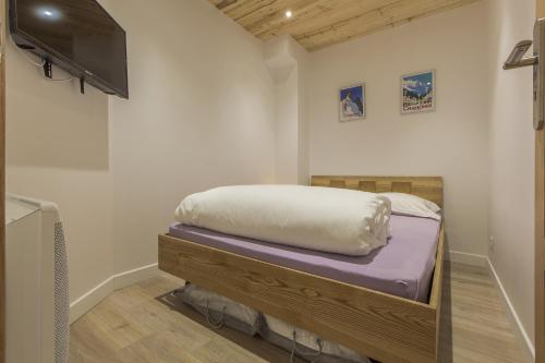 - une chambre avec un lit et une télévision à écran plat dans l'établissement Résidence Les Périades, à Chamonix-Mont-Blanc