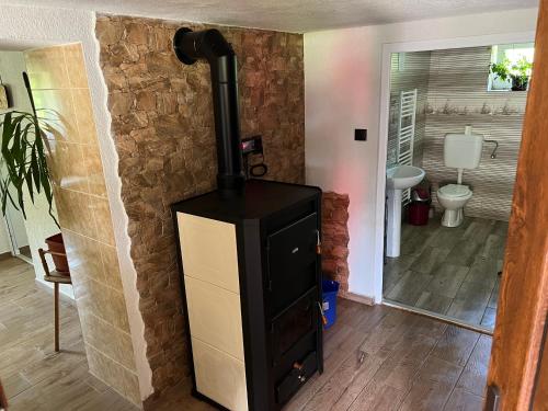 a wood stove in a room with a bathroom at HuniHáz Apartman in Sovata
