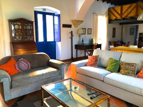 uma sala de estar com dois sofás e uma mesa de vidro em Casa no Campo T3 e Piscina de PortusAlacer em Portalegre