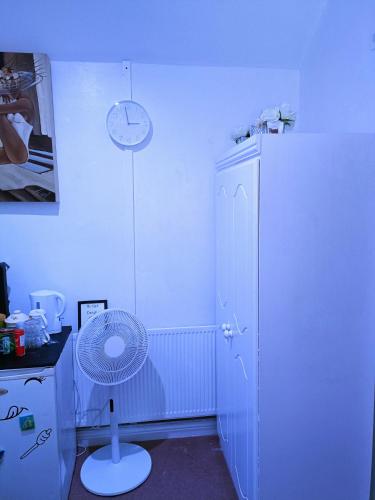 a room with a white refrigerator and a fan at Homestay BedSpace in Birmingham