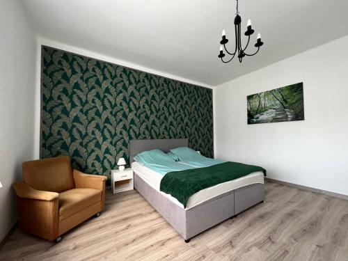 1 dormitorio con 1 cama y 1 silla en AranyLak vendégház en Abádszalók