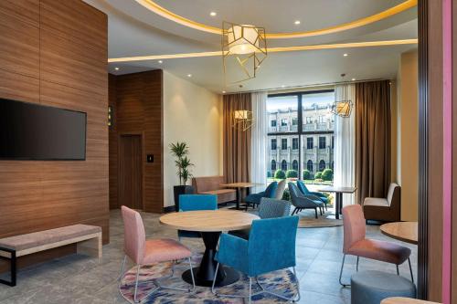 a hotel lobby with a table and chairs at Hampton By Hilton Tashkent in Tashkent