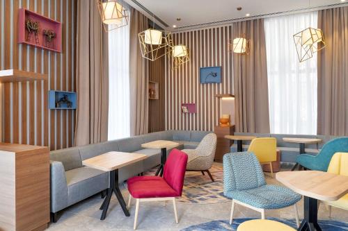 a restaurant with colorful chairs and tables and windows at Hampton By Hilton Tashkent in Tashkent