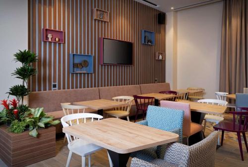 a restaurant with tables and chairs and a couch at Hampton By Hilton Tashkent in Tashkent