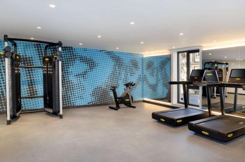 a fitness room with a blue wall with a gym at Hampton By Hilton Tashkent in Tashkent