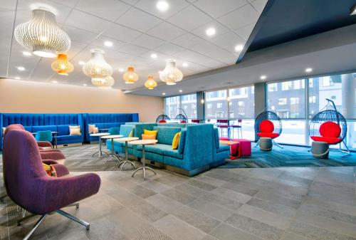 a lobby with couches and tables and chairs at Tru By Hilton Ashburn One Loudoun, Va in Ashburn