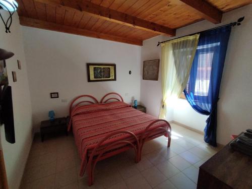 1 dormitorio con 1 cama roja en una habitación en CARRELA 'E BRETA en Thiesi
