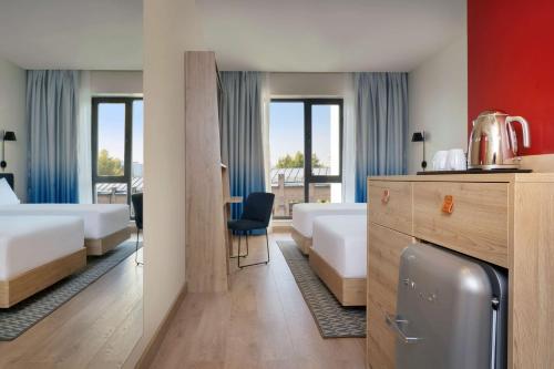 um quarto de hotel com duas camas e uma secretária em Hampton By Hilton Tashkent em Tashkent