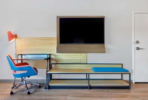 a room with a desk and chairs and a tv at Tru By Hilton Ashburn One Loudoun, Va in Ashburn