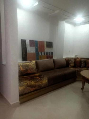 ein Sofa in einem Zimmer mit einem Gemälde an der Wand in der Unterkunft Family Beach Saïdia in Saidia 