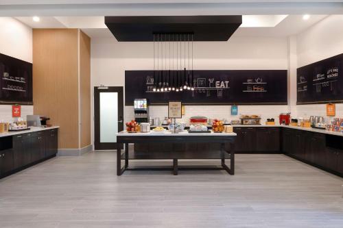 a large kitchen with a table in the middle of a room at Hampton Inn & Suites Burlington, Ontario, Canada in Burlington