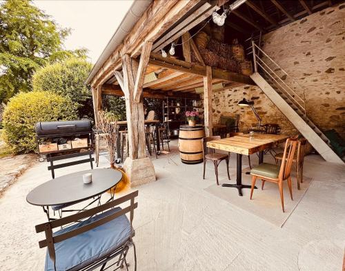 eine Terrasse mit Tischen, Stühlen und einem Grill in der Unterkunft La Cour Verte Chambres d'Hôtes in Montépilloy