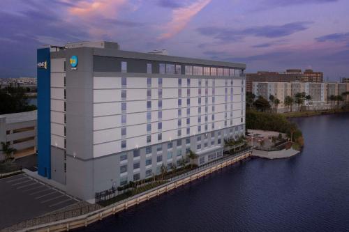 Un gran edificio blanco al lado de un cuerpo de agua. en Tru By Hilton Miami Airport South Blue Lagoon, Fl, en Miami