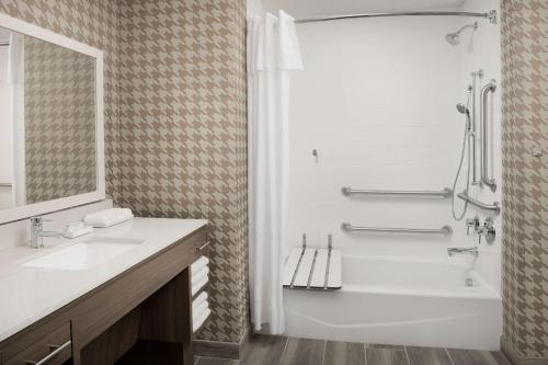 Baño blanco con bañera y lavamanos en Home2 Suites By Hilton Miami Airport South Blue Lagoon en Miami