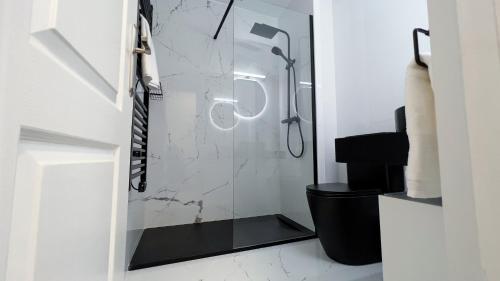y baño con ducha y aseo negro. en Modern Apartment in Salou Town Centre, en Salou