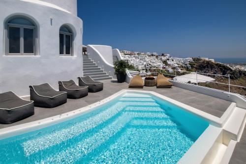 a swimming pool on the side of a house at Eteoro Suites in Imerovigli