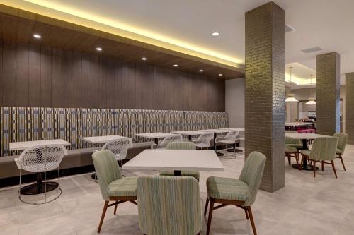 a restaurant with tables and chairs and a wall at Hilton Garden Inn Temecula in Temecula