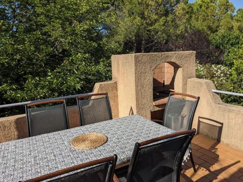 une table et des chaises sur une terrasse avec un four à pizza dans l'établissement Gîte Botanica, à Gignac