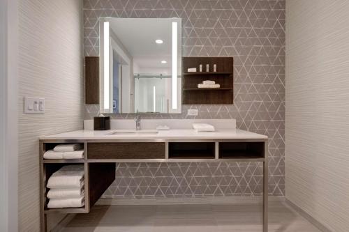 W łazience znajduje się umywalka i lustro. w obiekcie Hilton Garden Inn Temecula w mieście Temecula