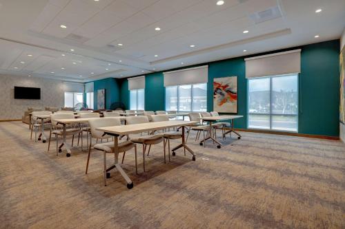 a conference room with tables and chairs and a screen at Hilton Garden Inn Temecula in Temecula