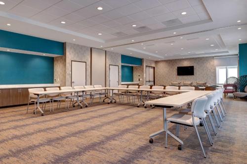 a conference room with tables and chairs and a screen at Hilton Garden Inn Temecula in Temecula