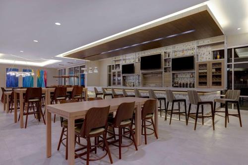 a large room with a bar with tables and chairs at Hilton Garden Inn Temecula in Temecula