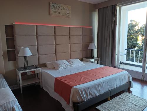 a bedroom with a large bed and a large window at Estoril Beach in Estoril