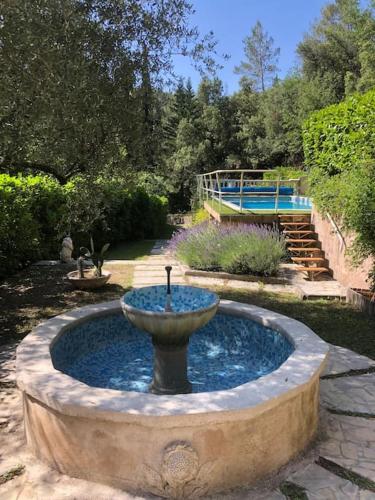 a fountain in the middle of a garden at Villa piscine 30 minutes de Nice in Le Broc