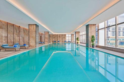 a swimming pool with blue water in a building at Doubletree By Hilton Suzhou Wuzhong in Suzhou