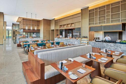 a restaurant with tables and chairs and a bar at Hilton Suzhou Wuzhong in Suzhou
