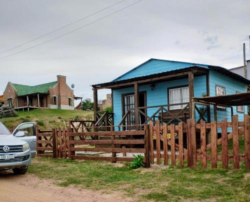 een blauw huis achter een houten hek bij Veniteconmigo in Punta Del Diablo
