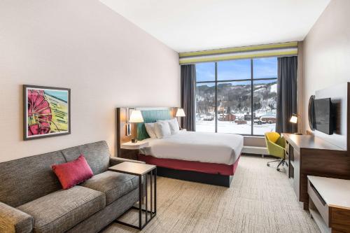 una camera d'albergo con letto e divano di Hampton Inn & Suites Houghton a Houghton