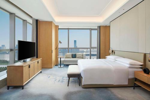 a hotel room with a bed and a television at Hilton Suzhou Wuzhong in Suzhou