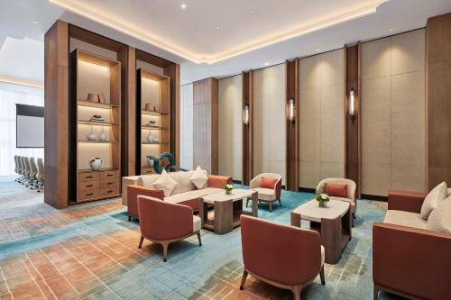a lobby with a waiting room with couches and tables at Hilton Suzhou Wuzhong in Suzhou
