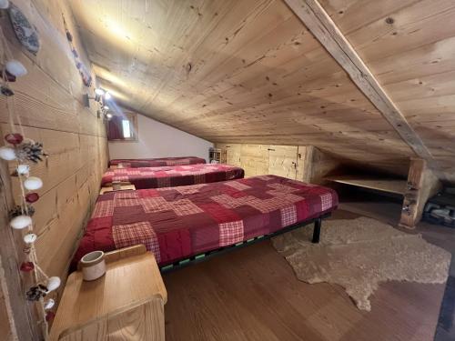 une chambre avec deux lits dans un grenier dans l'établissement Reposire 8, appartement 5 pers plein sud, à La Clusaz
