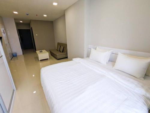 a large white bed in a room with a chair at Lovina 20-12A Formosa Residence in Nagoya