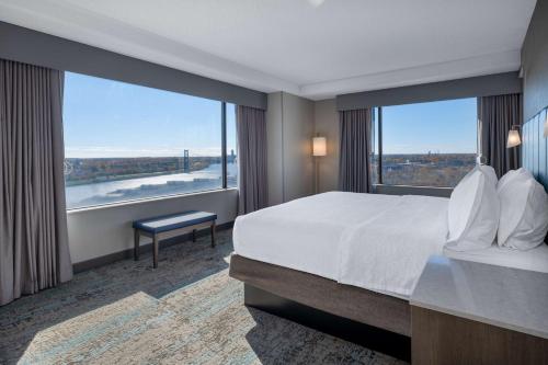 a hotel room with a bed and a large window at Homewood Suites By Hilton Toledo Downtown in Toledo