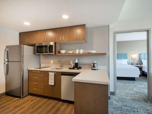 a kitchen with a refrigerator freezer next to a bedroom at Homewood Suites By Hilton Toledo Downtown in Toledo