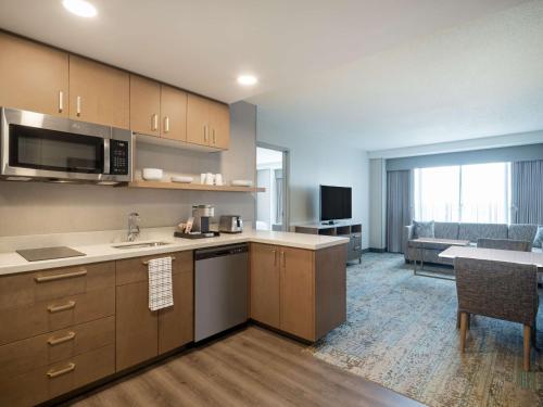 a kitchen with a sink and a living room at Homewood Suites By Hilton Toledo Downtown in Toledo