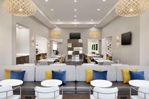 a restaurant with white tables and blue pillows at Homewood Suites By Hilton Mcdonough in McDonough