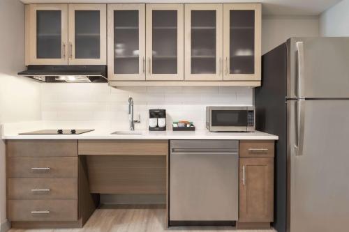 a kitchen with a sink and a refrigerator at Homewood Suites By Hilton Mcdonough in McDonough